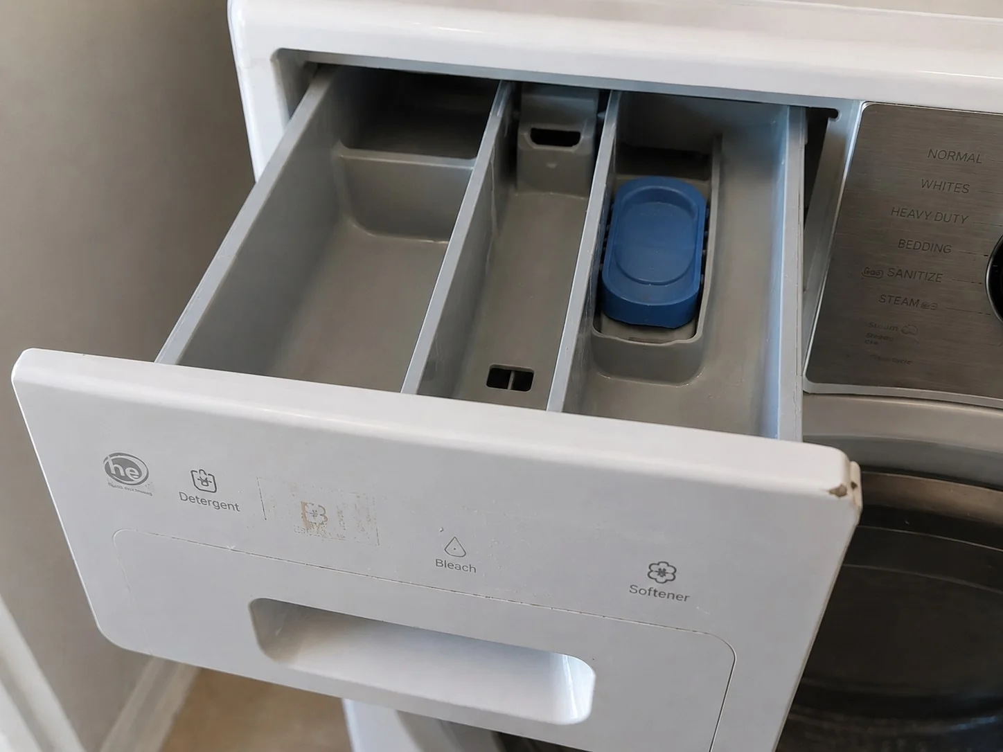 The same dispenser drawer after cleaning, compartments and upper edge clear of mold and residue