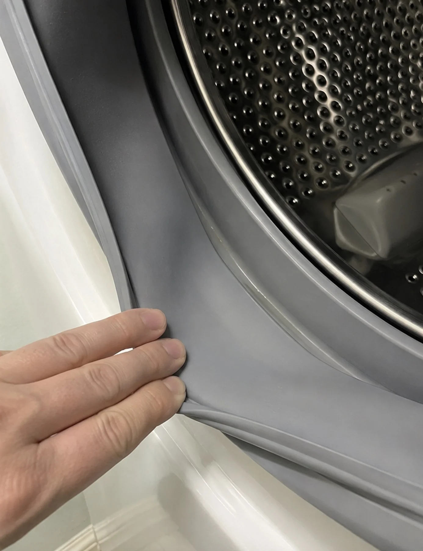The same door gasket fold held open after cleaning, plain grey rubber with no residue